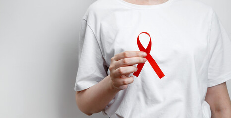 World AIDS Day. Woman holding red AIDS awareness ribbon