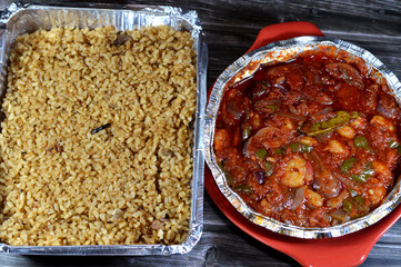 medium sized peeled shrimps baked in the oven with red sauce, laurel, dill, parsley, slices of onions and garlic with red rice fish with onions, seafood cuisine of a shrimp bake and rice