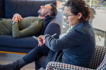 The psychologist checks the time during a psychotherapy session