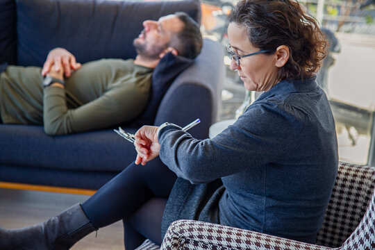 The psychologist checks the time during a psychotherapy session