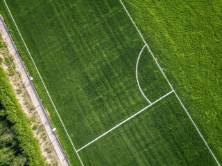 Obraz premium Aerial View of a Lush Green Soccer Field Featuring Textured Grass and Center Line with Ample Space for Copy and Text, Perfect for Sports-Related Marketing or Presentation Needs