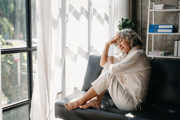 Old woman sit Depression haired  pensive glance Standing with bottle pills and pills by window