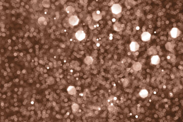 Brown, mocha mousse sparkling glitter bokeh background, abstract defocused texture. Holiday lights. Demonstrating color, trend 2025 year