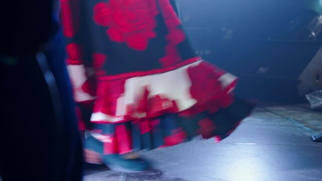 Lady in vibrant traje de flamenca shows dance moves on stage