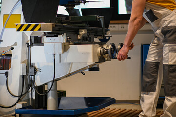 Factory worker operating a milling machine, demonstrating workplace safety with proper attire and focused attention