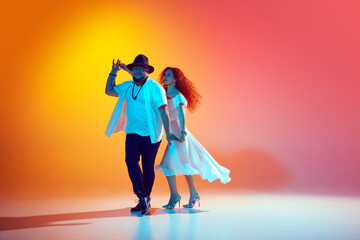 Joyful Latin dancers rehearse with intensity, perfecting their salsa steps and rhythms in neon...