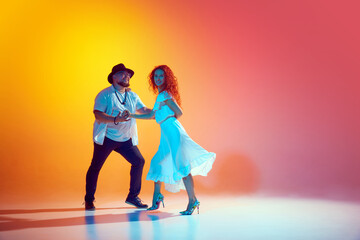 Energetic salsa. Dancers during training session work on perfecting their steps and rhythm in neon...