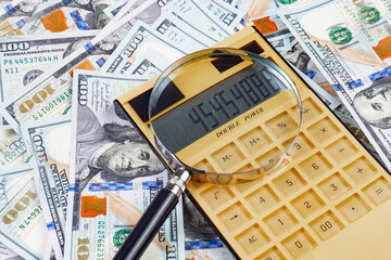 calculator, dollars and magnifying glass on the white background