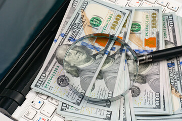 Close up of dollar banknotes and magnifying glass on chart background © vizafoto