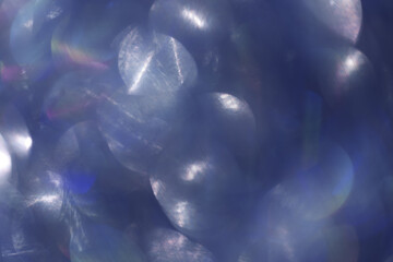 Vibrant abstract image with soft-focus dark blue bokeh light patterns with shimmering highlights, festive texture background, blurred backdrop trend color year, white sunlight glare on future dusk