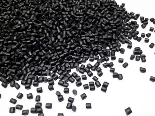 Black masterbatch granules on white background, polymer carrier of color pigment in plastic industry. Suitable for plastic company catalog design.