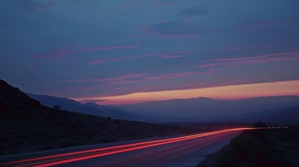 A car zooms past leaving a trail of light as it disappears into the distant horizon.