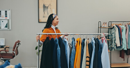 Clothing rack, creative and outfit with fashion designer woman in textile workshop for decision....