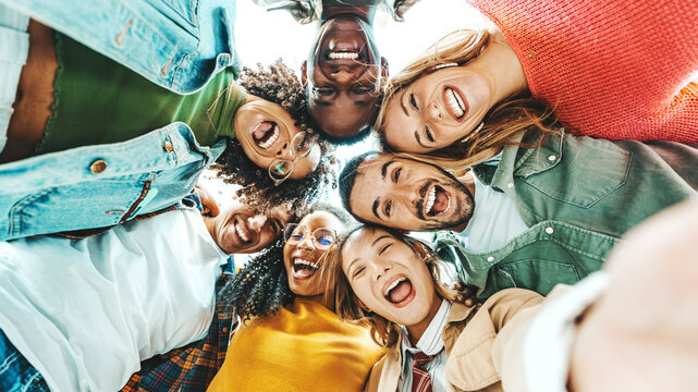 Multicultural group of friends taking selfie picture with smart mobile phone outside - Millenial people walking on city street - Life style concept with guys and girls hanging out together