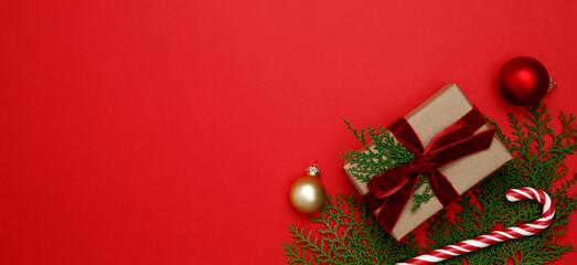 Christmas ornaments, thuja branches, and candy cane, gifts wrapped in craft paper