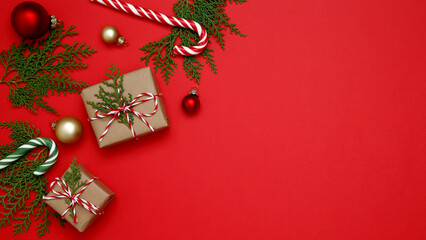 Christmas ornaments, gifts wrapped in craft paper,  thuja branches, candy cane arranged