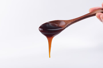 A wooden spoon of oyster sauce