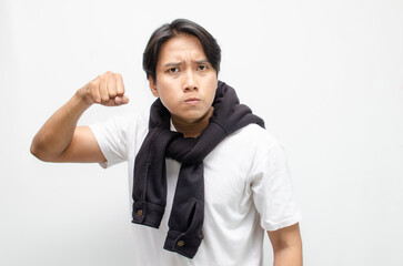 Angry Young Asian Man Shouting and Clenching His Fist in Rage