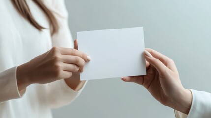 Women holding blank gift card on light grey background closeup
