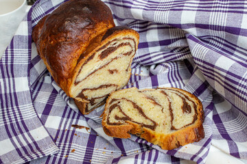 Cozonac, Romanian traditional sweet bread with walnut filling, sliced , on a checkered patterned...