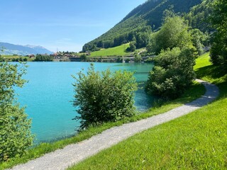 Fototapeta premium Promenade along Lake Lungern or recreational trails along the natural reservoir Lungernsee - Canton of Obwald, Switzerland (Spazierwege entlang des Lungererses - Kanton Obwalden, Schweiz)