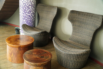 Two comfy wicker chairs with two wooden tables in a stylish and relaxing lounge. Relaxing Lounge Chairs and Wooden Tables.