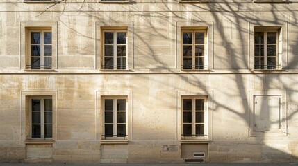 Fototapeta premium Parisian minimalist building, facing a wall with windows and doors, sunny afternoon light, serene urban scene, no people present.