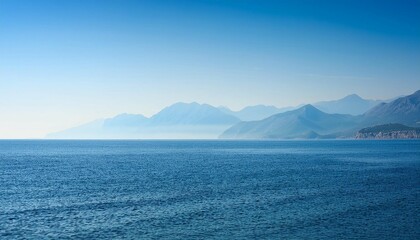 adriatic sea coastline in the early morning with mountains far in the haze minimalist background
