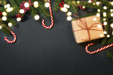 Christmas holiday background with gifts, holly berries, garland, fir tree and decoration on black...