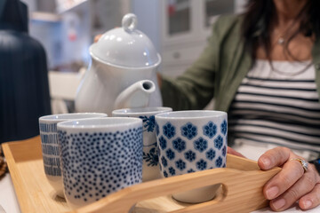 Young woman pouring hot tea into beautiful cup