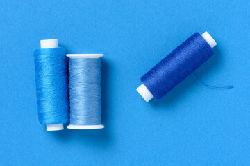 Blue thread spools background with copy space for text close-up flat lay top view