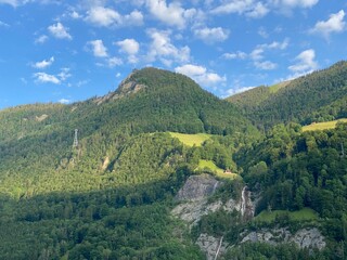 Fototapeta premium Alpine mountains above Lake Lungern or mixed forest above the natural reservoir Lungernsee - Canton of Obwald, Switzerland (Alpenberge und Mischwald oberhalb des Naturstausee Lungererses - Schweiz)