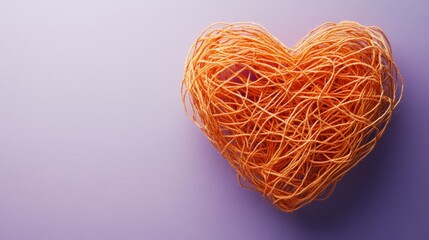 A heart made of string is on a purple background The heart is orange and has a stringy texture Concept of warmth and love