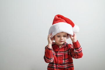 Adorable Child in Santa Hat Holding Candy Canes at Christmas