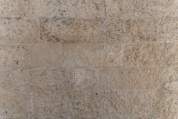 abstract background of beige stone lined wall close up