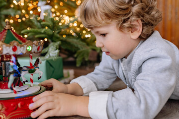 Young child enjoys exploring a vintage carousel ornament during the festive holiday season