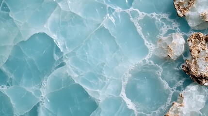 Turquoise water texture with crystalline rocks along the shore in a sunny coastal location