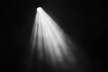 Fotobehang Bright spotlight cuts through misty smoke. God’s light radiates beams down creating fantasy glow. Black background enhances mystical magical atmosphere. © ana