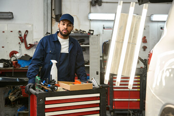 A skilled mechanic works with tools in an auto shop, demonstrating dedication and expertise.