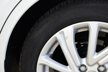 Close up of car wheel with scratches on car tyre