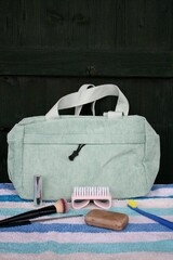 Hellgrüne Kulturtasche (Kosmetiktasche) aus hellgrünem Cord  für Reisen. Nagelbürste, Nagelfeile, Seife, Lippenstift, Zahnbürste auf gestreiftem Frotteehandtuch.