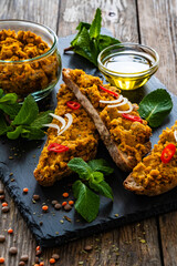 Tasty sandwiches with lentil pate on wooden table	