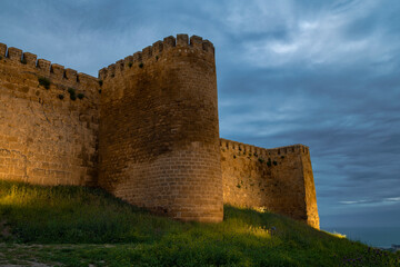 The tower and wall of the ancient fortress of Naryn-Kala in the cloudy May twilight. Derbent, Dagestan. Russian Federation