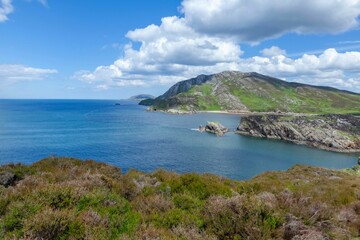 Fototapeta premium Rugged coastline with clear blue waters and mountains.