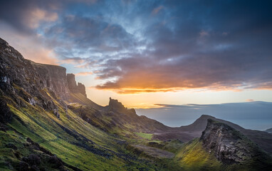 Majestic sunset over rugged cliffs and green hills in a remote landscape