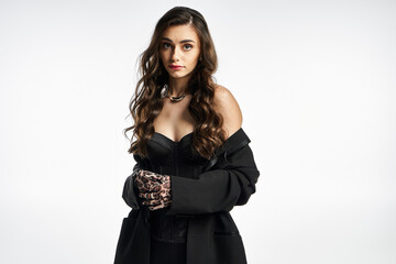 A young woman with long hair showcases her chic outfit while exuding confidence and charm.