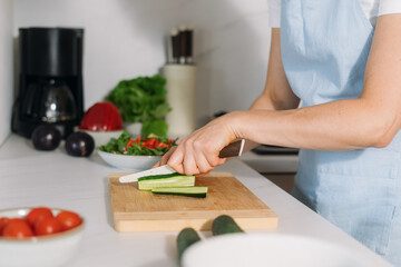 Woman preparing healthy food in modern kitchen during daytime