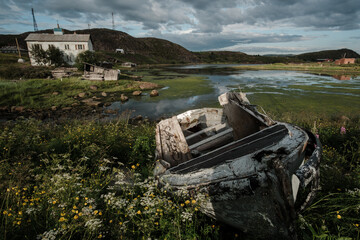 An old boat stands on the shore of the bay in Teriberka