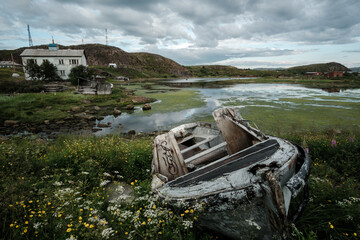 An old boat stands on the shore of the bay in Teriberka