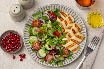 close up of fried halloumi cheese with fresh vegetable salad